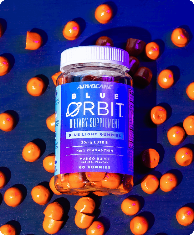 Bottle of Blue Orbit sitting on a table with multiple Blue Orbit gummies on the table.