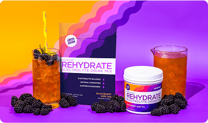Rehydrate Blackberry Iced Tea Canister and Gusset bag sitting next to blackberries and glasses of iced tea on a purple and yellow backgorund.