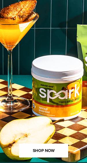 Spark Prickly Pear canister on top of a cutting board surrounded by a sliced pear and martini glass filled with mixed Spark Spiced Peartini. Shop Now