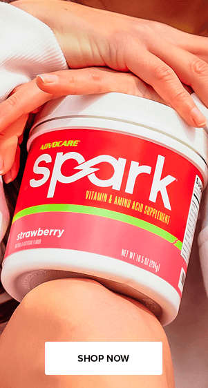 A bag of Spark Limeade in the foreground with a woman wearing yellow athletic gear stretching in the background.