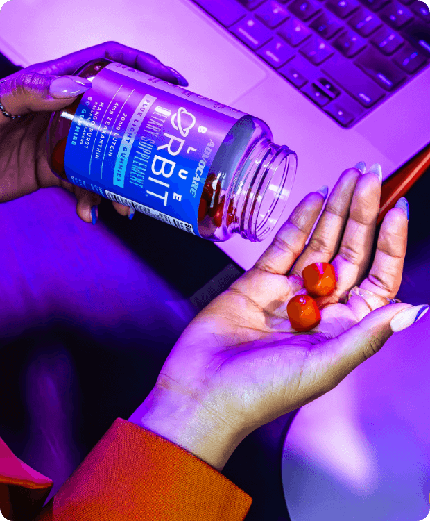 Person pouring 2 Blue Orbit gummies into their hand from the Blue Orbit bottle.