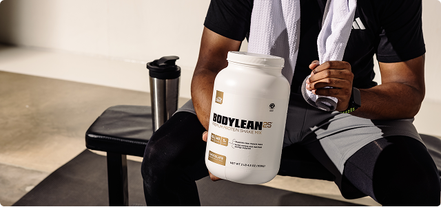 Man sitting on workout bench and holding a can of BodyLean25