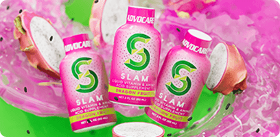 Three Slam Dragon Fruit bottles surrounded by a cut up dragon fruit and purple swirly liquid.