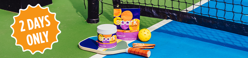 2 Days Only! Spark Passion Fruit on top of pickleball rackets on a pickleball court.